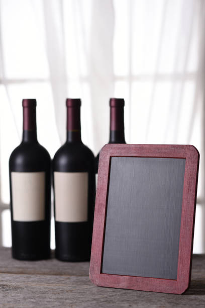 istock Three bottles of red wine and blank chalk board 1413676434