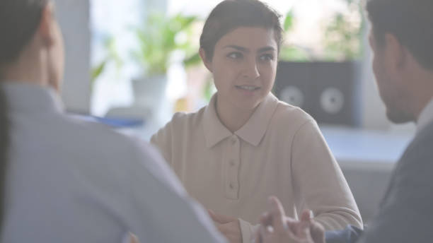 istock Serious Business People Talking While Sitting in Office 1413681156