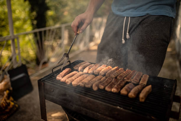 Man Preparing Food On Barbecue Grill in nature