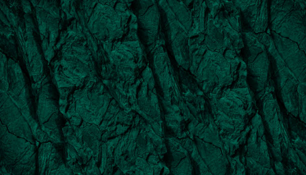 istock Dark green rock texture. Toned rough mountain surface with cracks. Emerald green color. Stone granite background. 1413682021