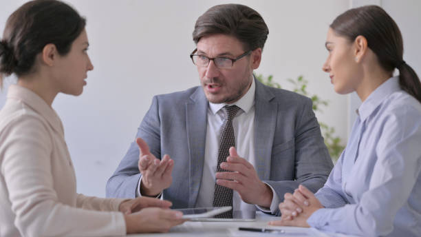 istock Middle Aged Businessman and Female Colleagues having Conversation 1413682519
