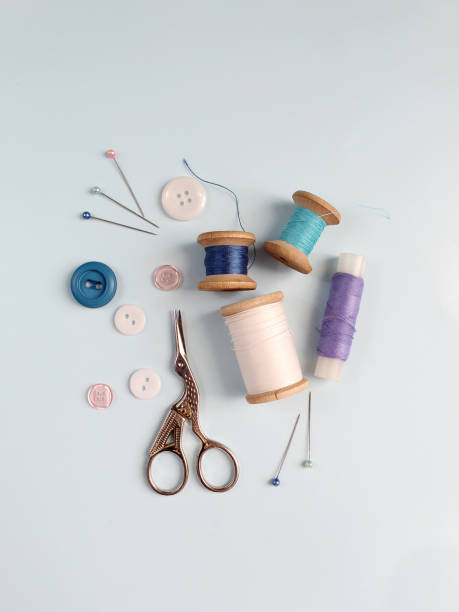 istock Sewing accessories and fabric on a blue background. Sewing threads, needles, pins, fabric, buttons and sewing centimeter. top view, flatlay 1413685925