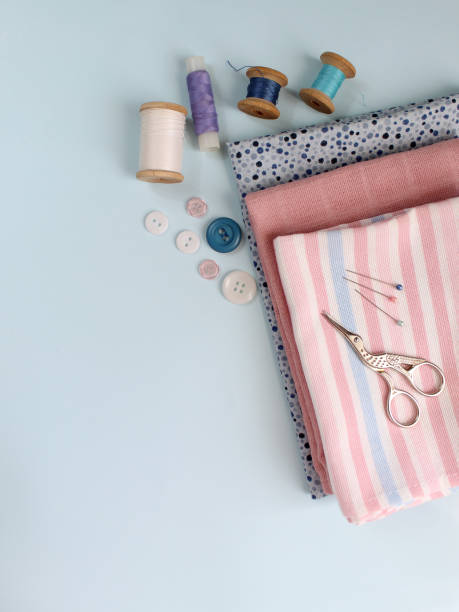 istock Sewing accessories and fabric on a blue background. Sewing threads, needles, pins, fabric, buttons and sewing centimeter. top view, flatlay 1413685945