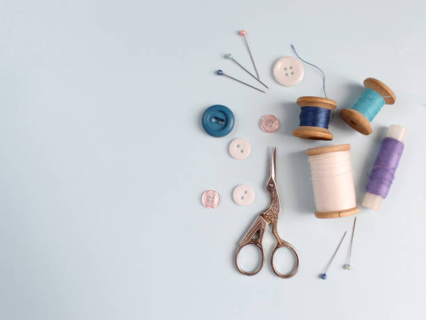 istock Sewing accessories and fabric on a blue background. Sewing threads, needles, pins, fabric, buttons and sewing centimeter. top view, flatlay 1413685988