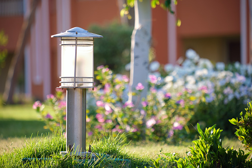 Outdoor lamp on yard lawn for garden lighting in summer park.