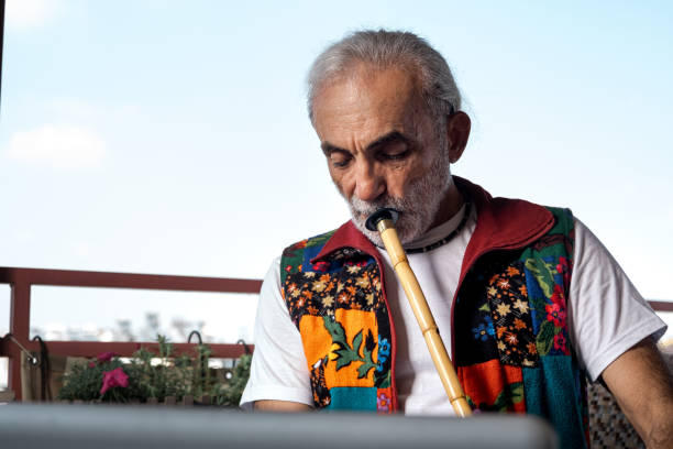istock Old man playing a wind instrument, video conferencing, laptop conversation, master, education 1413694417