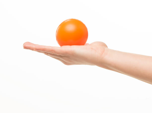 istock female hands holding an orange sponge ball on a white background isolated 1413700846