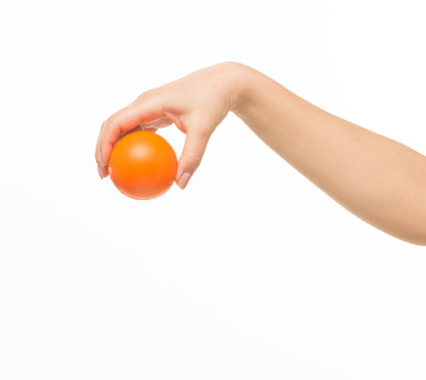 istock female hands holding an orange sponge ball on a white background isolated 1413700849