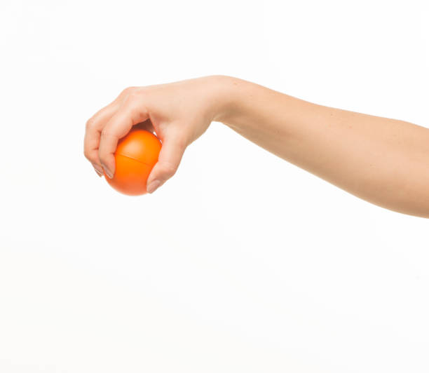 istock female hands holding an orange sponge ball on a white background isolated 1413700862