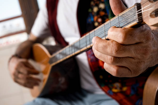 Close-up tying, hands of man playing saz Close-up hands of man in his 60s who has been playing musical instruments for many years.model playing musical instrument. sedge stock pictures, royalty-free photos & images