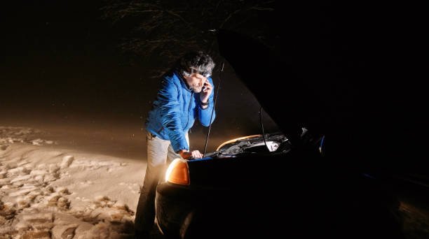istock Man with car issues on winter road, phone calling for help. 1413704593