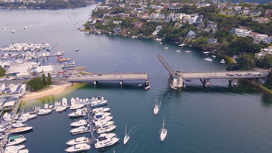 Aerial drone view of Spit Bridge across the Middle Harbour at The Spit between Mosman and Seaforth, Sydney, NSW, Australia raised to allow boats to pass through