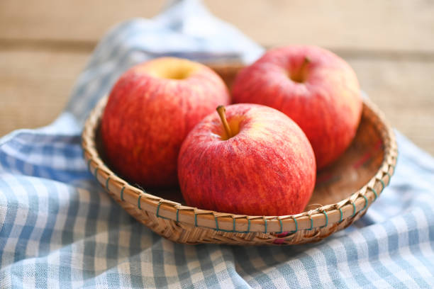 istock apple fruit on basket on the wooden table, ripe red apples. 1413720754
