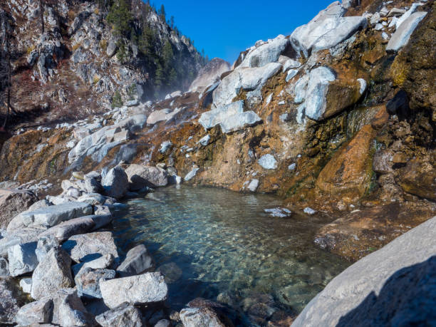 source chaude dans l’idaho avec de la vapeur qui flotte pendant la matinée - hot spring photos et images de collection