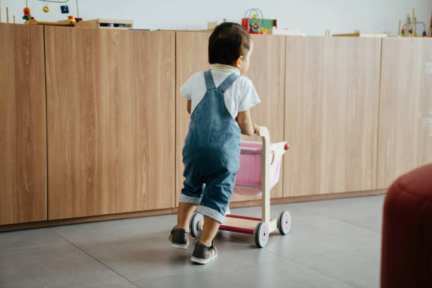 istock cute baby push trolley in the school 1413730126