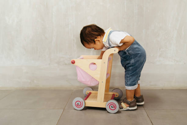 istock cute baby push trolley in the school 1413730132