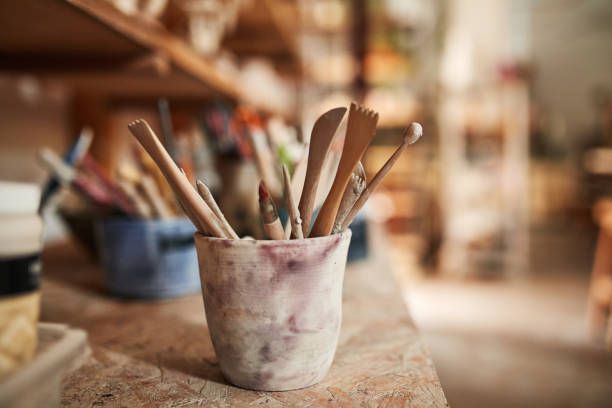 Paint brush in clay jug and tools on wooden table background texture. Paintbrush for painting as artistic paint still life. Abstract art concept