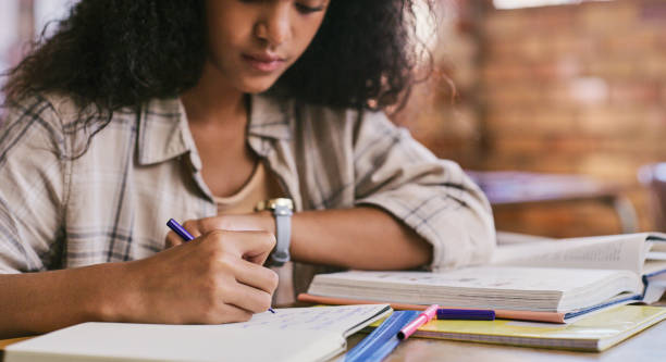 l’élève intelligente et créative planifie et écrit des notes dans ses livres à l’école à l’intérieur de la salle de classe. une jeune adolescente lisant, étudiant et apprenant des connaissances dans une classe éducative - scholarship holder photos et images de collection