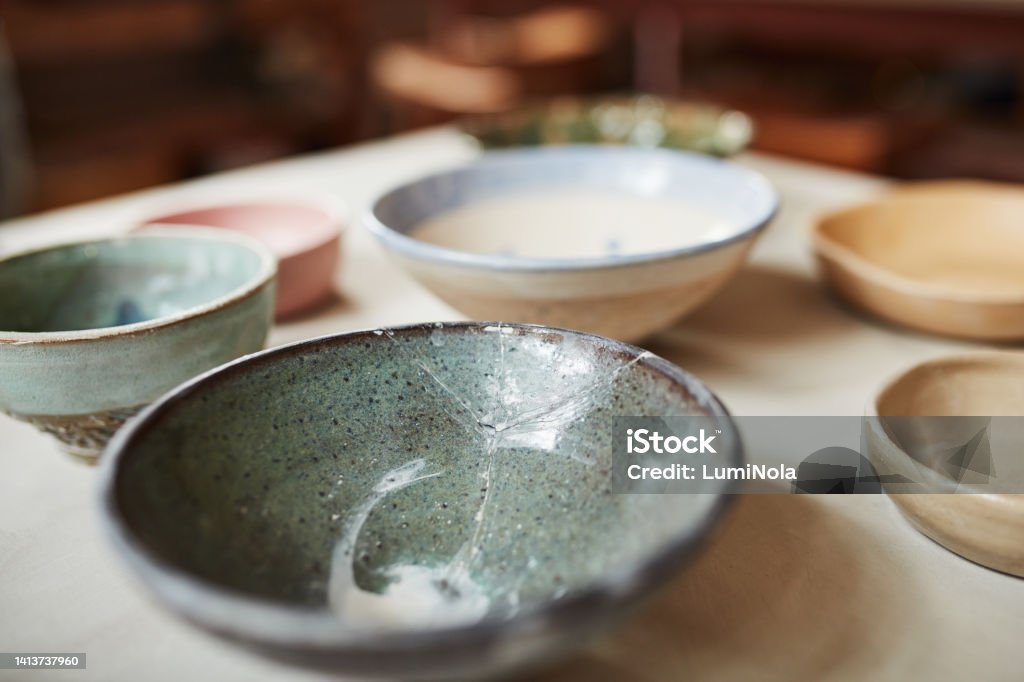Empty Japanese ceramic plates or bowls with a traditional and vintage design on a kitchen table. Closeup detail of antique style dishes or pottery. A dining setup or decor at a ceremony Empty Bowl Stock Photo