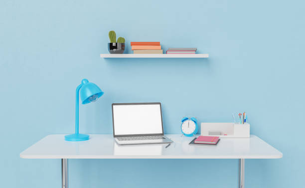 istock Laptop on working table with lamp and alarm clock 1413738273