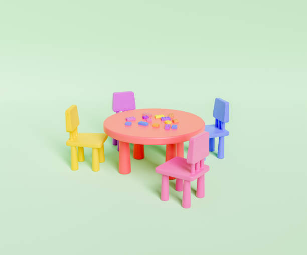 Colorful chairs placed at round table with scattered plastic blocks stock photo