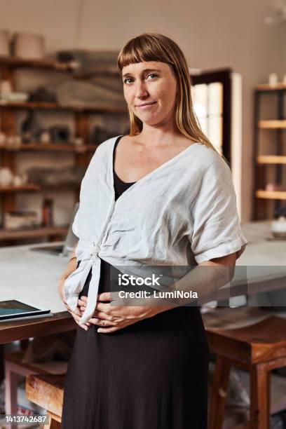 Pregnant Woman Parent Or Working Mother Standing In A Workshop And Looking Happy To Be A Small Business Owner Portrait Of A Young Female Holding Her Stomach Feeling Positive And Confident Stock Photo - Download Image Now