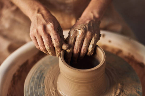 istock Hands making pottery, ceramic and clay on potters wheel for creative, relaxing and artistic hobby from above. Closeup of artist fingers shaping and creating unique and handmade craft inside workshop 1413753002