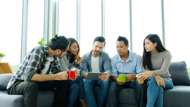 istock Group of happy creative team discussing while taking coffee break at office 1413754360