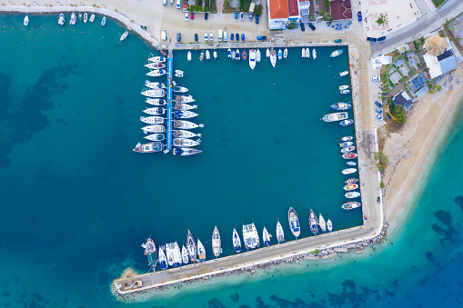 Aerial top view of a lot of white boats and yachts moored in marina. Top-down view of docked sailboats. Top down view of yachts. Luxury yacht Boat in a port. Marina lot sailboat. Harbor with boats.