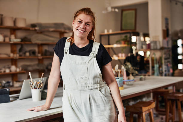 istock Potter, artist and entrepreneur looking confident and happy while standing in her workshop. Portrait of a creative female in her art studio. Smiling woman and owner of small pottery business 1413756159
