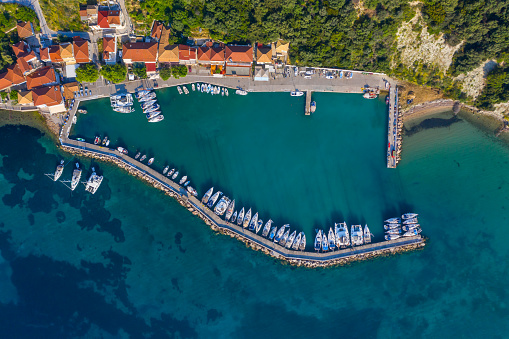 Small marina with catamaran yachts and sailboats in Greece. Kalamos Marina. Beautiful and cozy harbor in Greece. Old fishing village with port on the shore of the Ionian Sea. Travel by boat on the sea