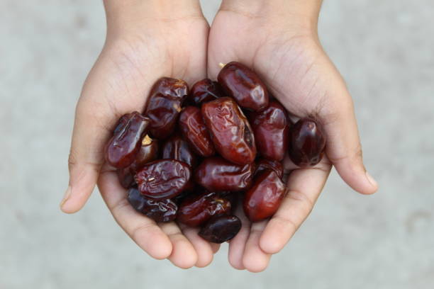 Hand full of dates Hand full with dates, signifies a healthy diet date fruit stock pictures, royalty-free photos & images