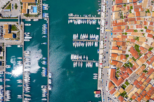 Aerial top view of a lot of white boats and yachts moored in marina. Top-down view of docked sailboats. Top down view of yachts. Luxury yacht Boat in a port. Marina lot sailboat. Harbour with boats