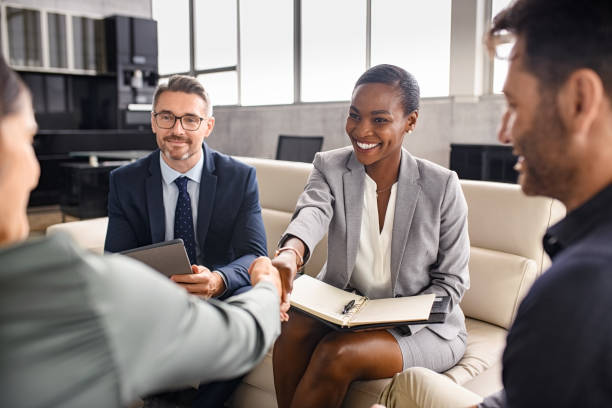 Business people shaking hands during meeting Smiling mature black businesswoman shaking hand with new client in modern office. Successful african american woman manager shaking hands with executive during business meeting. Professional ceo signing a deal with handshake with new partner. business people stock pictures, royalty-free photos & images