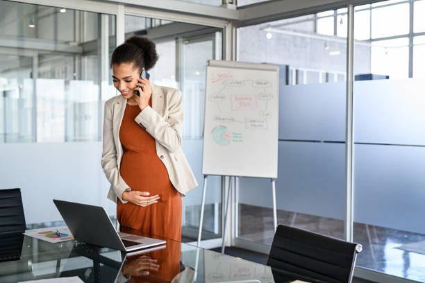 Pregnant black business woman working in office with copy space stock photo