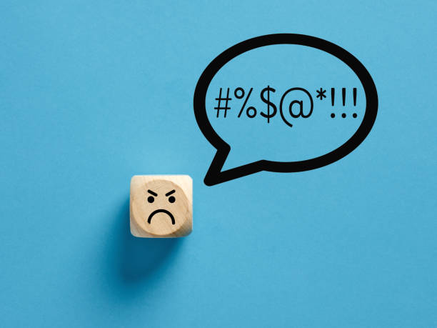Angry face icon on a wooden cube with swearing or swearwords icons in a speech bubble. Angry face icon on a wooden cube with swearing or swearwords icons in a speech bubble. Swearing and bad language concept. curse stock pictures, royalty-free photos & images