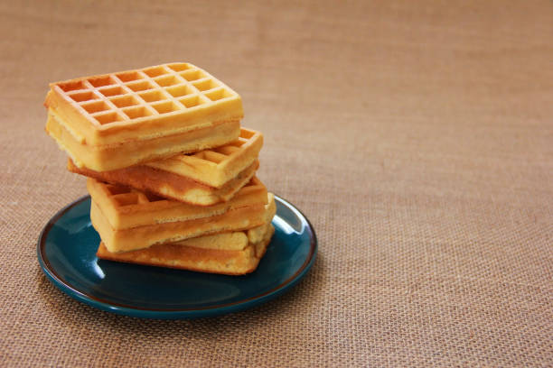 istock sweet fluted belgian waffles in a blue plate on a brown background 1413762545