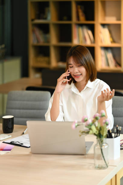 istock Concentrated female economist using laptop an working with document at office desk. 1413762720