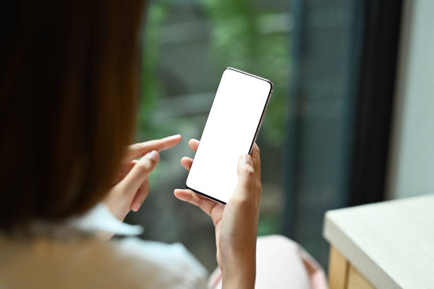 istock View over shoulder young woman holding mobile phone. Blank display for your advertise text. 1413762721