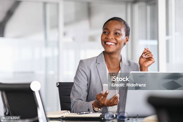Smiling Businesswoman Looking Up While Working Stock Photo - Download Image Now - Business, Office, Women