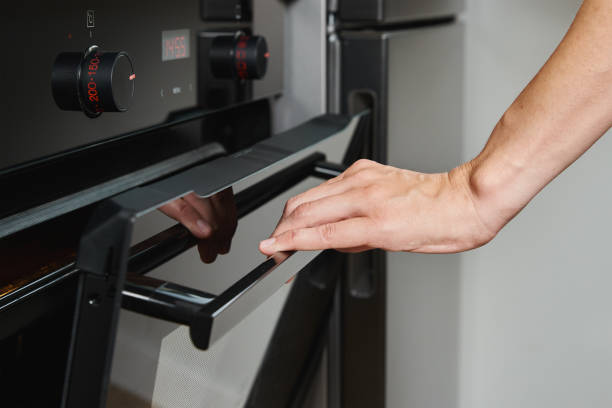 istock Female open electric oven door 1413763566