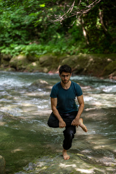 istock boy doing yoga by the river 1413763976