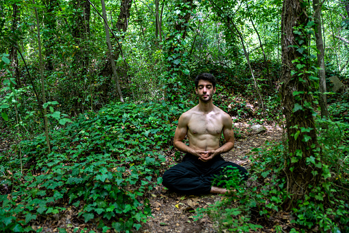 boy doing yoga in the woods bareback in tranquility