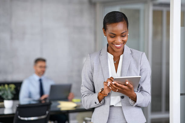 Black business woman using digital tablet in meeting room stock photo