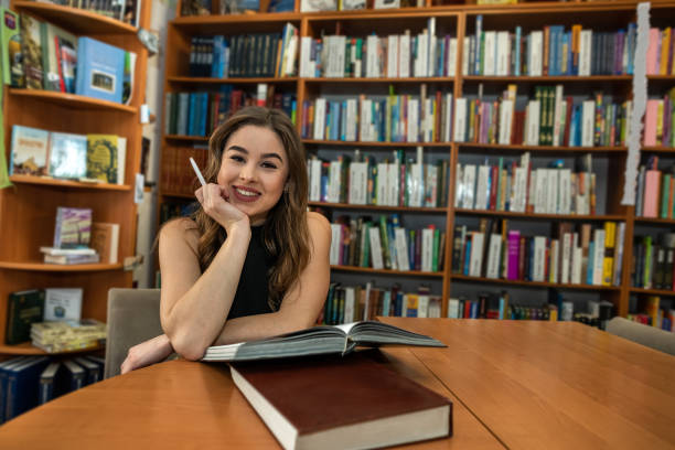 istock female student looking for book in university library 1413768231