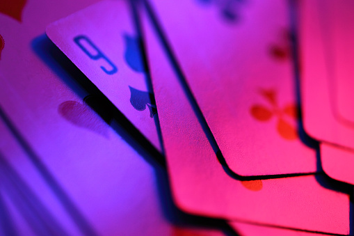 Playing cards in colored lighting.