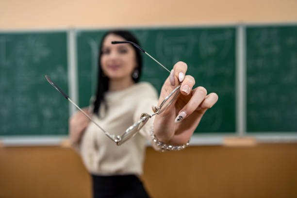 Young teacher in classroom against blackboard. education concept