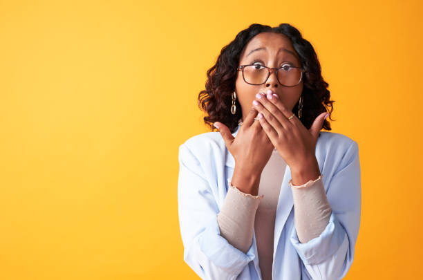 Surprised, shocked and amazed lady with an omg emoji expression on her face isolated on a yellow background with copy space. Portrait of a funky woman with her hands on her mouth after hearing gossip Surprised, shocked and amazed lady with an omg emoji expression on her face isolated on a yellow background with copy space. Portrait of a funky woman with her hands on her mouth after hearing gossip wtf stock pictures, royalty-free photos & images