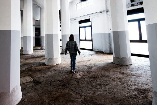 Woman silhouette in abandoned industrial building.