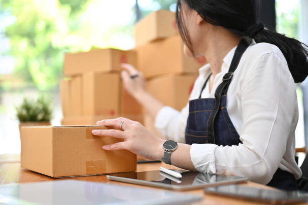 istock Asian female e-commerce startup preparing her shipping packages in the office. 1413772353